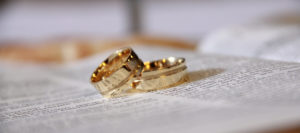 Two gold wedding bands on top of a book