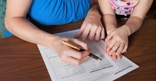 A woman and her daughter working on a child support worksheet