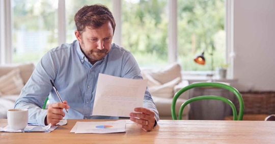 A man reviewing his finances at his kitchen table
