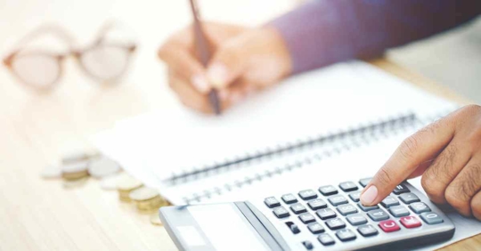 Someone working on a budget with a calculator