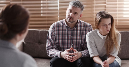 A man explaining his thoughts while his wife angrily looks away