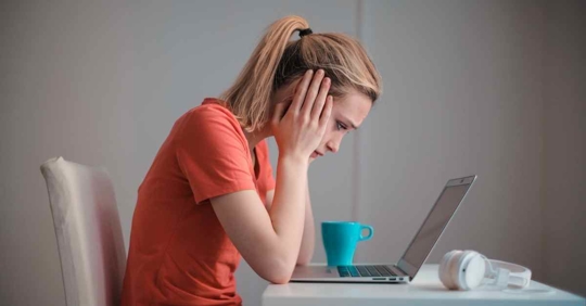 A woman staring at her computer. She looks sad