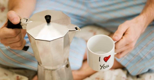 A man about to pour coffee or tea into a mug. The mug reads "I love you," except love is replaced with a red heart emoji.