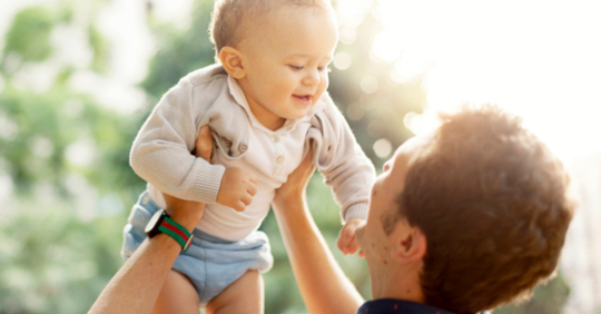 Man holding up his child