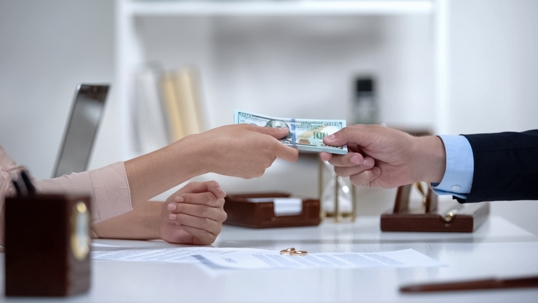 couple in lawyer's office exchanging money