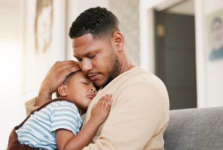 father holding young son in his arms
