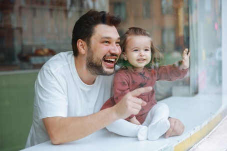 father and daughter looking out the window